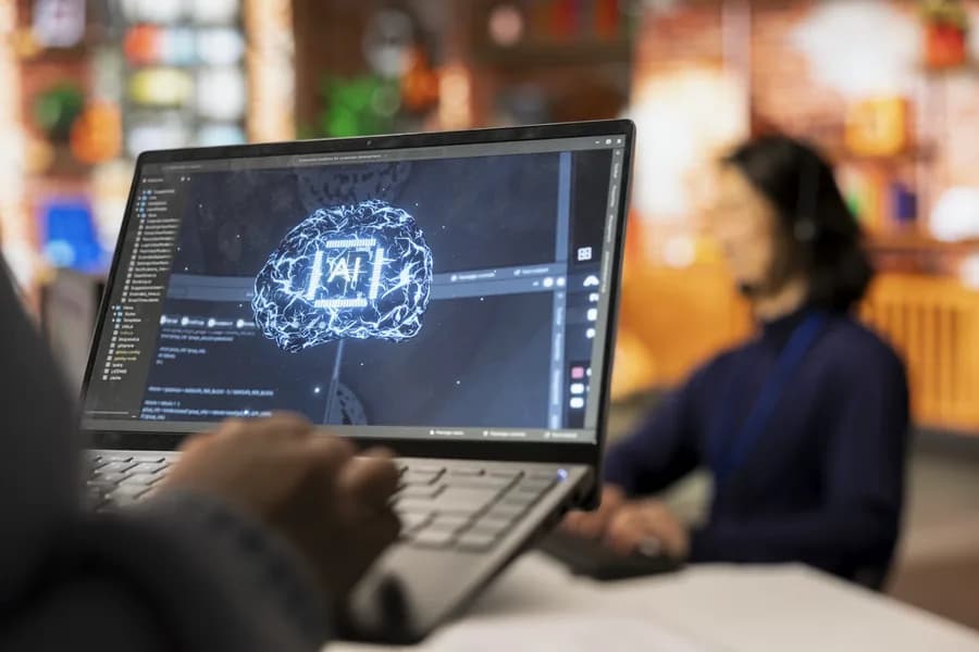 An engineer at a laptop with a model's diagram on the screen