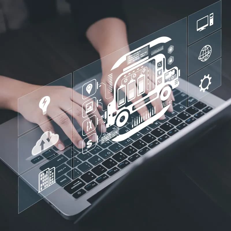 An engineer at a laptop with a monitoring-system hologram