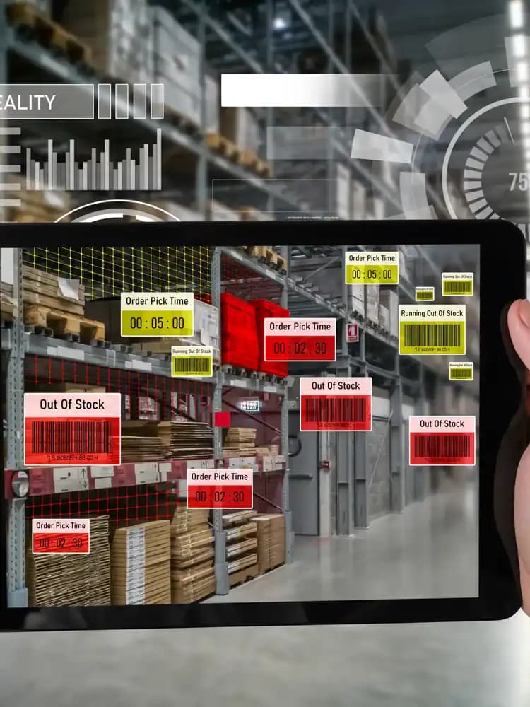 A tablet showing stock labels over a warehouse aisle