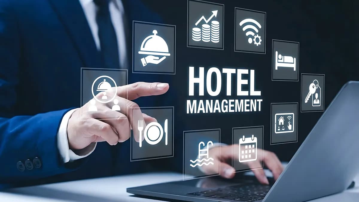 A businessman touching a hotel management hologram over his laptop