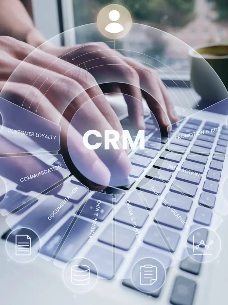 Hands typing on a laptop with a CRM overlay