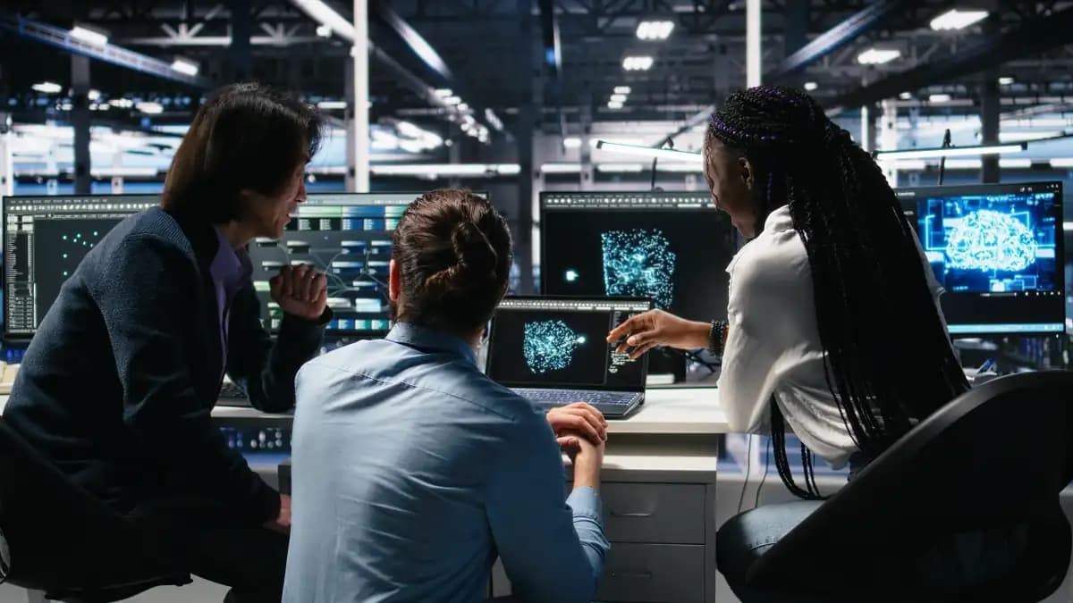 Engineers reviewing AI infrastructure on screens in a server room