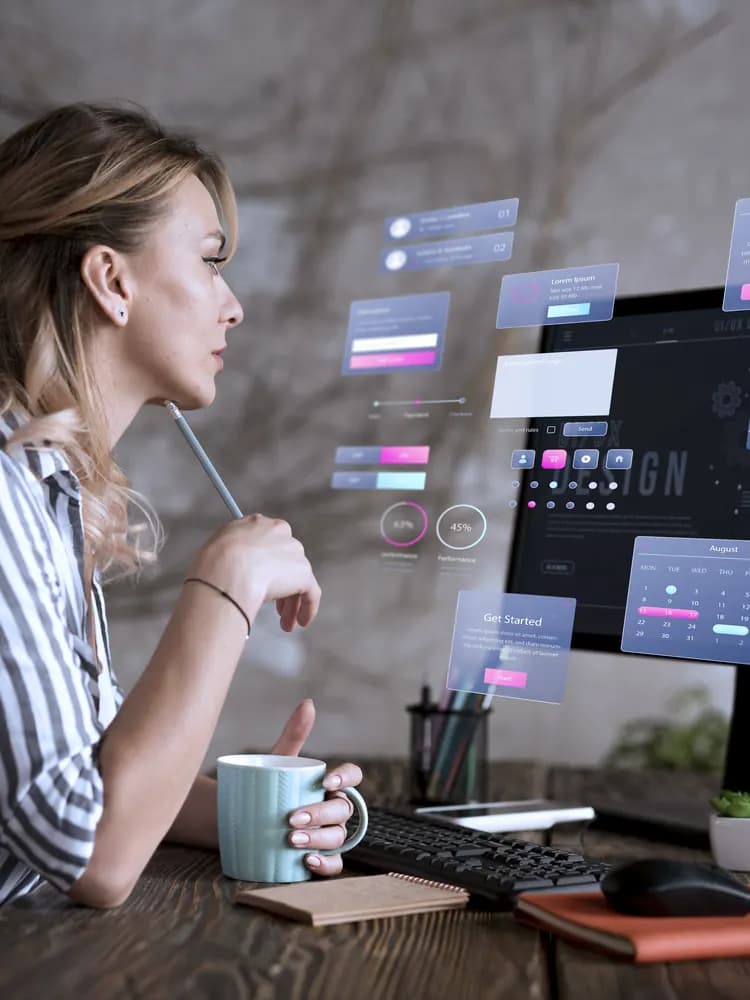 A woman at a monitor reviewing an app interface design