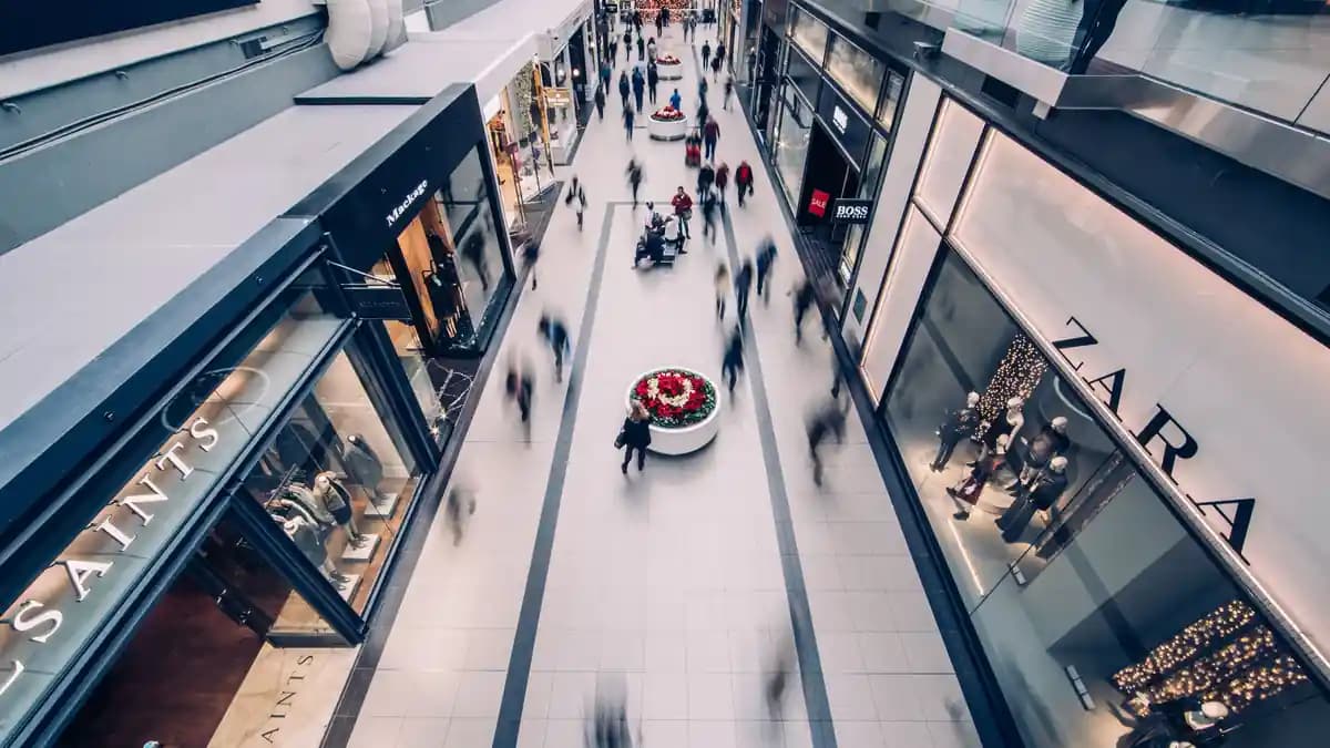 Shoppers crossing a mall atrium seen from above
